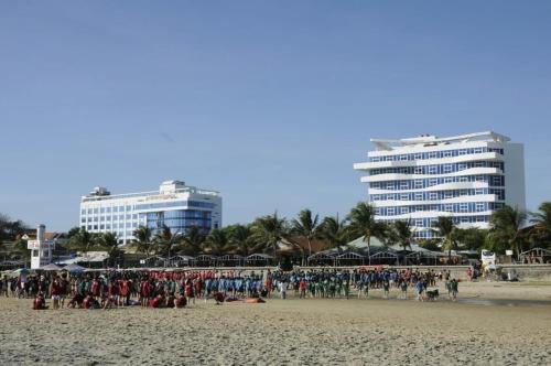 隆海Nguyễn Kim Motel的一群人,在海滩上,有建筑背景