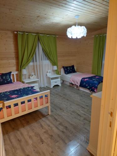 锡比乌盐矿镇Cabana Oprișor的绿窗帘间内的两张床