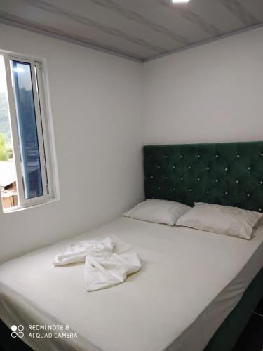 巴亚索拉诺Apartamentos Olaya!的一张带黑色床头板的白色床和一个窗口