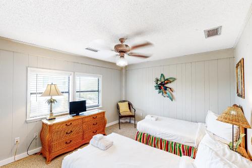 圣乔治岛Knot Too Shabby的一间卧室配有两张床和一张书桌及电视