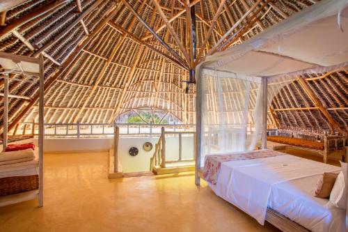 迪亚尼海滩Aestus Villas Resort的一间卧室设有一张床和稻草屋顶
