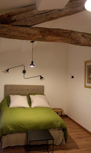 马泽尔贝鲁恩农村旅馆的一间卧室设有一张绿色的床和木梁。