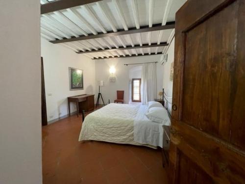 蒙特瓦尔基La Fattoria di Rendola的一间卧室配有一张床和一张书桌
