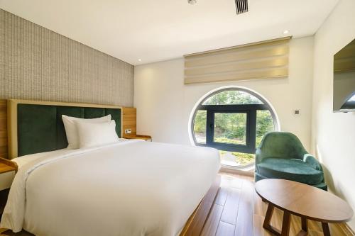 富国The Tahiti Beach Hotel的卧室配有白色的床和绿色椅子