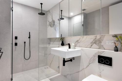 悉尼The Horizon Apartments by Urban Rest的白色的浴室设有水槽和淋浴。