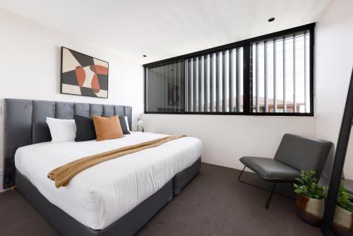 悉尼The Horizon Apartments by Urban Rest的一间卧室配有一张大床和一把椅子