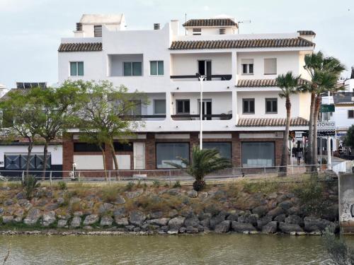 萨阿拉德洛斯阿图内斯霍斯佩德里亚多纳罗拉扎哈拉酒店的水体旁的白色建筑