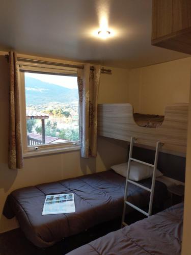 普罗普里亚诺Camping TIKITI的客房设有两张双层床和一扇窗户。