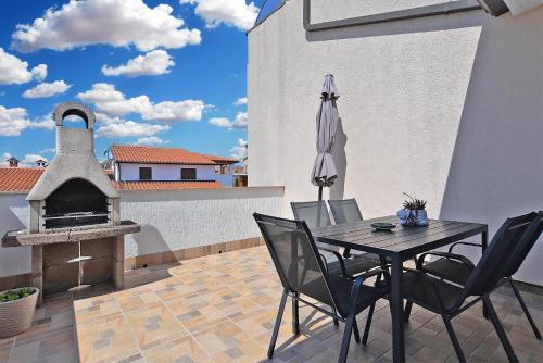 波雷奇Apartments Milka 2074的庭院设有桌子、遮阳伞和壁炉。
