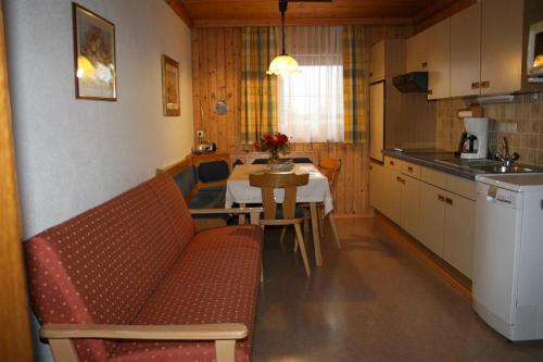 霍赫菲尔岑Ferienwohnungen Foidlhof的客厅设有厨房和一张沙发桌