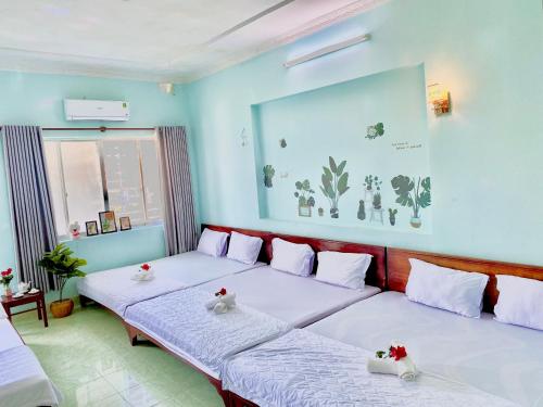 头顿THANH THẢO MOTEL的蓝色墙壁客房的两张床