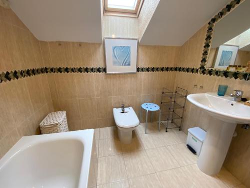 拉·格兰哈·圣·伊尔德阿方索十三世公寓酒店的带浴缸、卫生间和盥洗盆的浴室