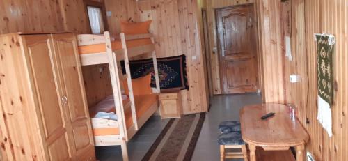 瑟尔尼察Ваканционно селище Ива的客房配有双层床、书桌和桌子。