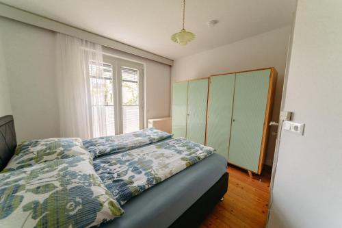 韦尔特湖畔克伦彭多夫Apartments Obir am Wörthersee的一间卧室设有一张床和一个窗口