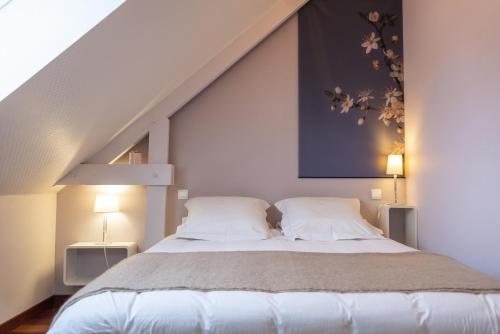 康卡勒L'Abri du Bon Vent的一间卧室配有一张大床和两个枕头