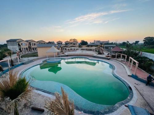 瓜廖尔Shubhim Hotel & Resort MIDWAY TREAT MPT FRANCHISE的一座享有日落美景的大型游泳池
