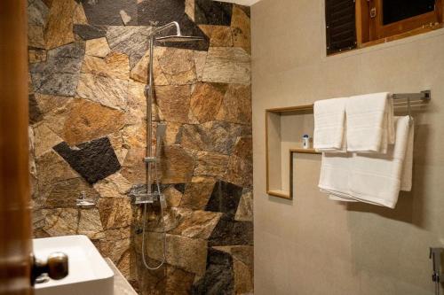 哈伯勒内Lina Hotel的带淋浴的浴室(带石墙)