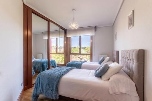 巴拉卡Confort junto a la Ría de Barakaldo的一间卧室设有两张床和大镜子