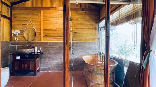 Làng CacDu Gia Panorama的一间带浴缸的浴室,位于一个木墙客房内