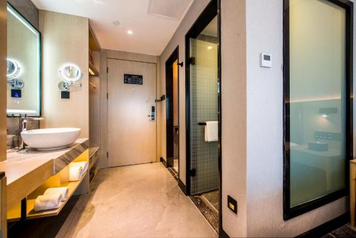 深圳Sky Hotel - Shenzhen Luohu Sungang BaoNeng Center的一间带水槽和镜子的浴室