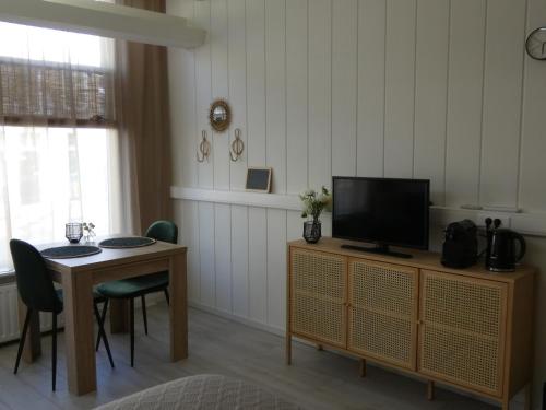弗利辛恩B&B Badhuis的客厅配有桌子和橱柜上的电视