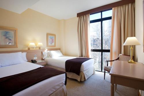 马德里巴西利卡广场酒店的酒店客房设有两张床和窗户。