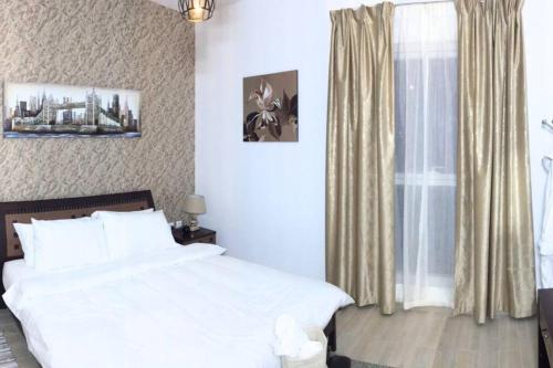 阿布扎比Cowboy Charm 1BR Apartment on Yas Island的卧室配有白色的床和窗户。