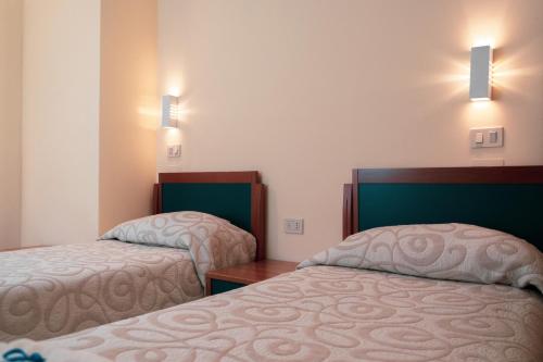 皮亚诺·德勒·皮耶韦阿西西及时行乐生活俱乐部酒店的酒店客房,设有两张床和两盏灯