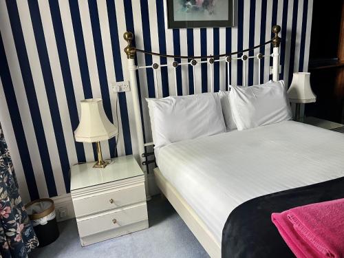 爱丁堡Eliza House的一间卧室配有一张蓝色和白色条纹的床