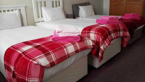 爱丁堡Eliza House的两张位于酒店客房的床,配有粉红色的毛巾