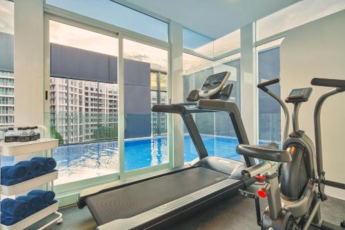 新加坡Citadines Connect City Centre Singapore的健身房设有跑步机和大窗户