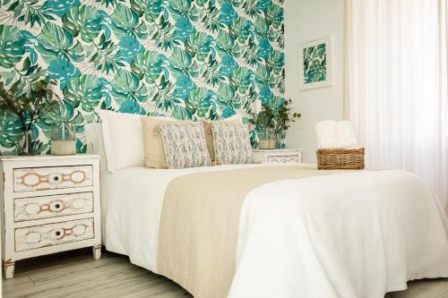 贝纳卢普-卡萨斯维耶哈斯Hostal Atalaya的一间卧室配有一张带花卉壁纸的床