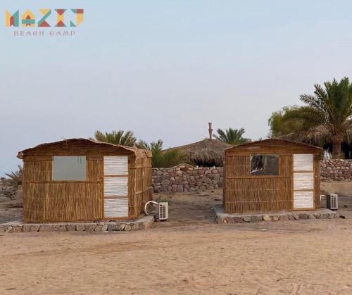 努韦巴Mazih beach camp的两座木棚,坐在沙漠的沙子上