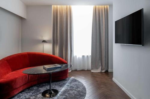 米兰Radisson Collection Hotel, Santa Sofia Milan的客厅配有红色的沙发和桌子