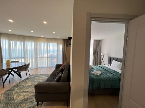 巴统Aparthotel Holiday Lux Batumi的一间卧室配有一张床、一张沙发和一张桌子