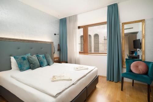 布达佩斯Hotel Memories Budapest的一间卧室配有一张大床和一张蓝色椅子