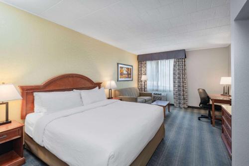约克约克温德姆花园酒店的酒店客房设有一张大床和一张书桌。