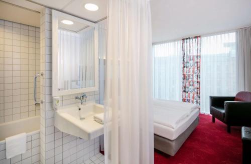柏林ARCOTEL Velvet Berlin的一间带床、水槽和浴缸的浴室