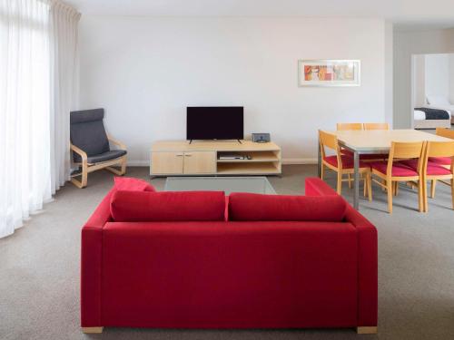城堡山Mantra Castle Hill Sydney, an Accor Hotel的客厅配有红色的沙发和桌子