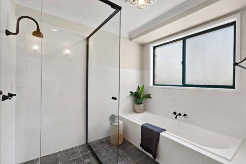 蒙恩维优Kangoo - Peacefull tree lined property, wildlife的带浴缸和玻璃淋浴间的浴室。
