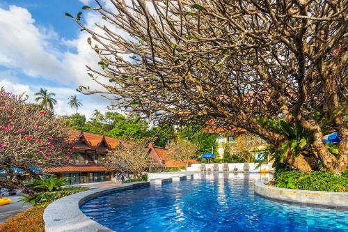 卡伦海滩Diamond Cottage Resort & Spa的一座位于树木繁茂的度假村前的游泳池
