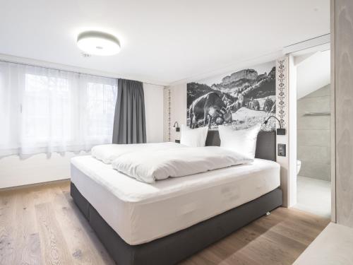 阿彭策尔Traube Restaurant & Hotel的卧室配有一张白色大床