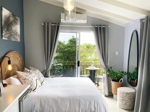 德班North Breeze Retreats的一间带白色床的卧室和一个阳台