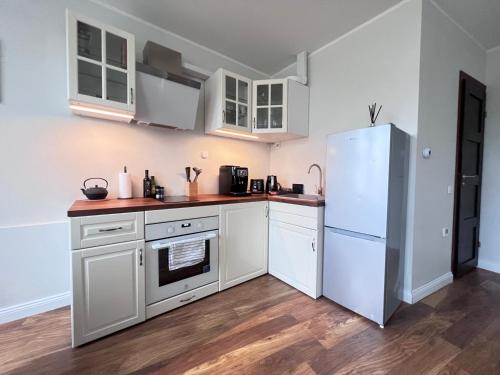 塔林CityView Apartment的厨房配有白色橱柜和冰箱。