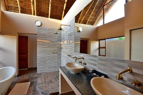 兰斯堡Black Rhino Game Lodge的一间带两个盥洗盆和大镜子的浴室