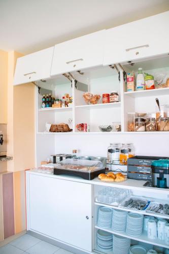 卡米尼亚Arca Nova Guest House & Hostel Caminha的厨房配有白色橱柜和架子