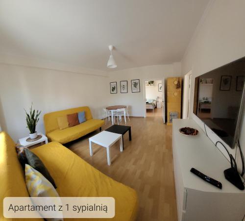 瓦古夫LuLu Apartamento Centro的客厅配有黄色的沙发和桌子