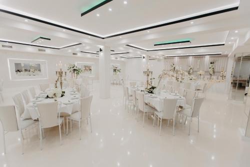 NevesinjeSvadbeni salon i prenoćište MILANOVIĆ的白色宴会厅配有白色桌子和白色椅子