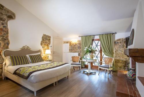 毕威格利亚努Residenza le Colline del Paradiso的卧室配有一张床和一张桌子及椅子