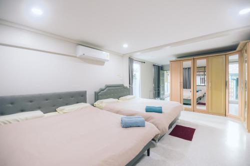 合艾Paradise Found - Hat Yai 292sqm Family Home的一间卧室设有两张床和大窗户